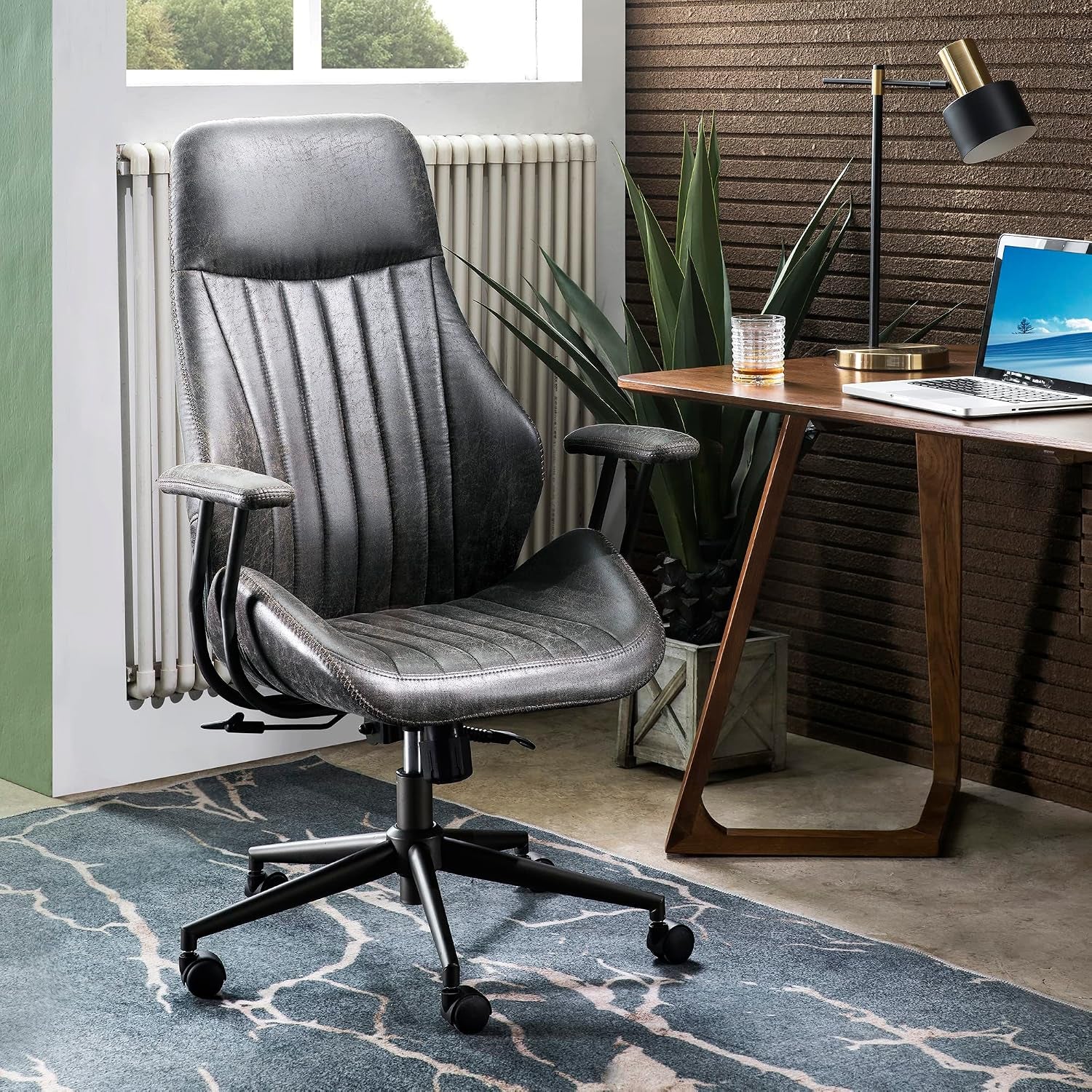 Dark gray faux-suede chair angled front-left next to a desk lamp and potted plant