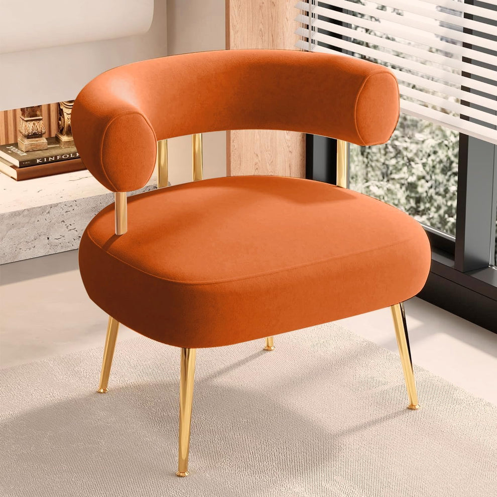 Orange round barrel accent chair with metal gold-tone legs angled front view in a living-room setting