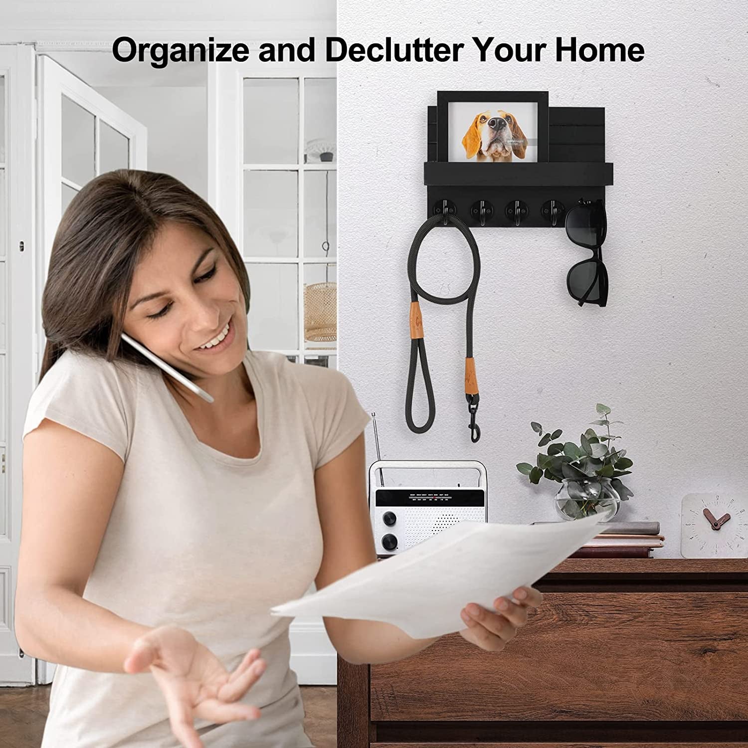 Black wall key holder with a framed dog photo, leash, and sunglasses in a home office.