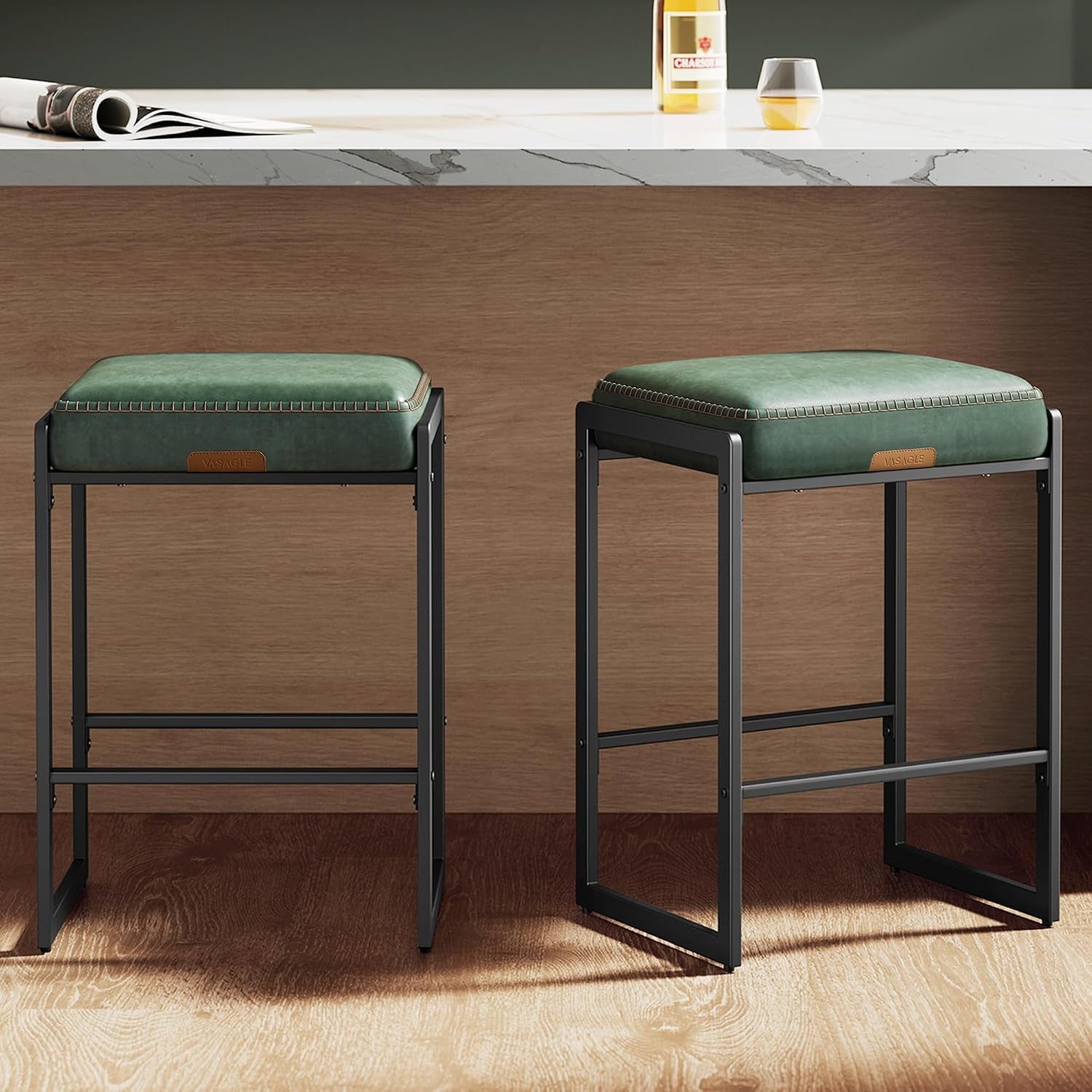 Pair of green PU-cushioned counter stools with black rectangular metal frames beside a wood-paneled island.