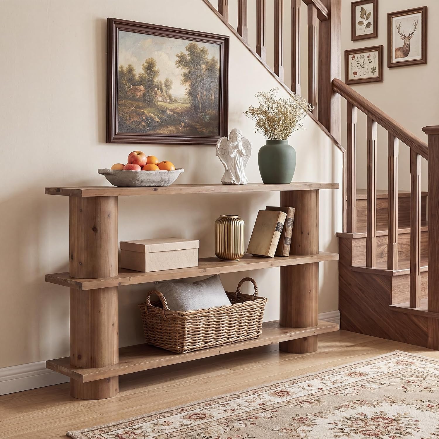 Three-tier console table beside a wooden staircase with framed landscape, vase and angel statue on top.