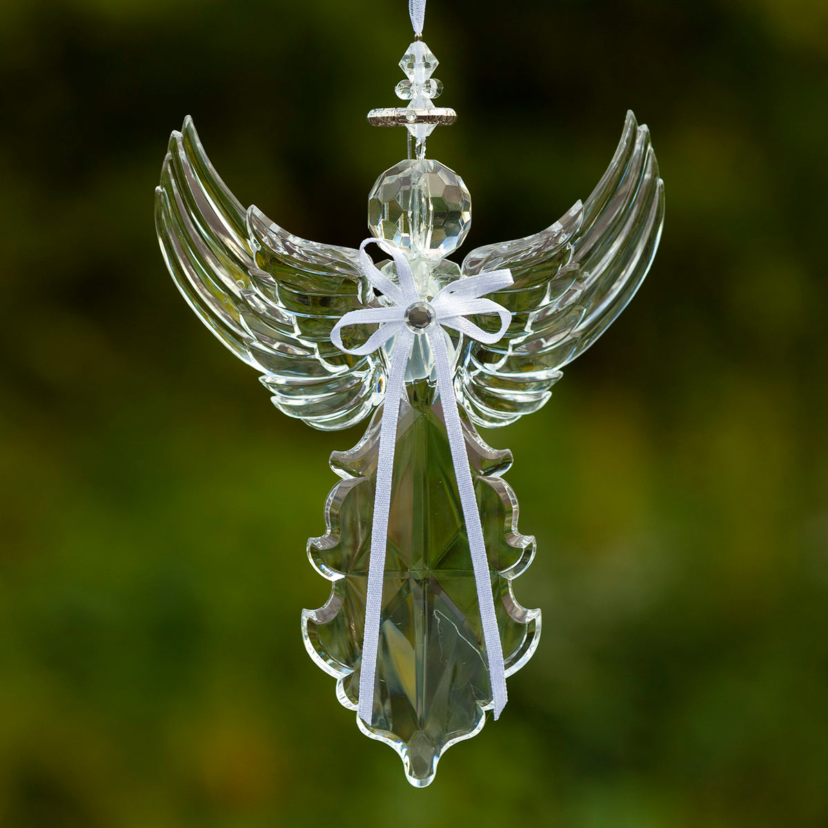 Clear hanging angel ornament with tall, upward-curving wings and a long faceted body, finished with a white bow.
