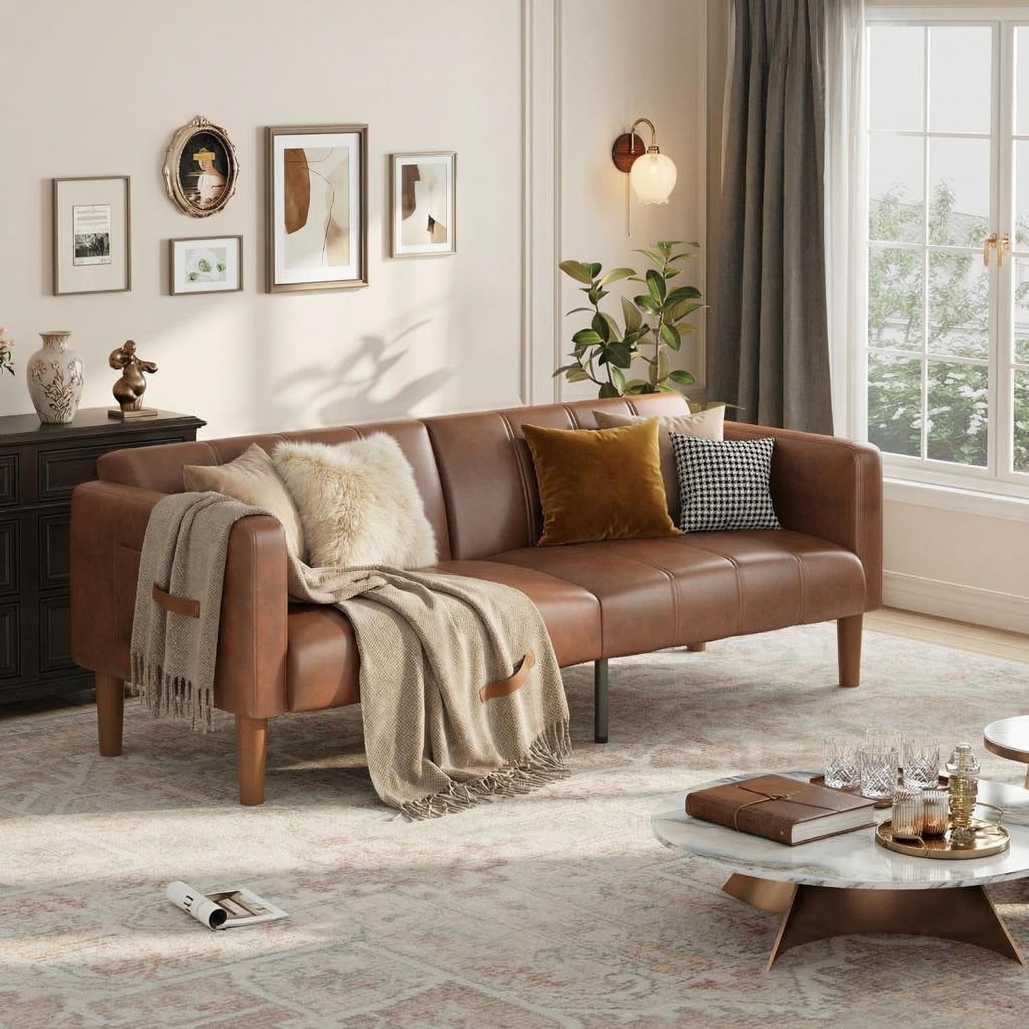 Brown faux leather futon sofa styled with throw pillows and a blanket in a living room