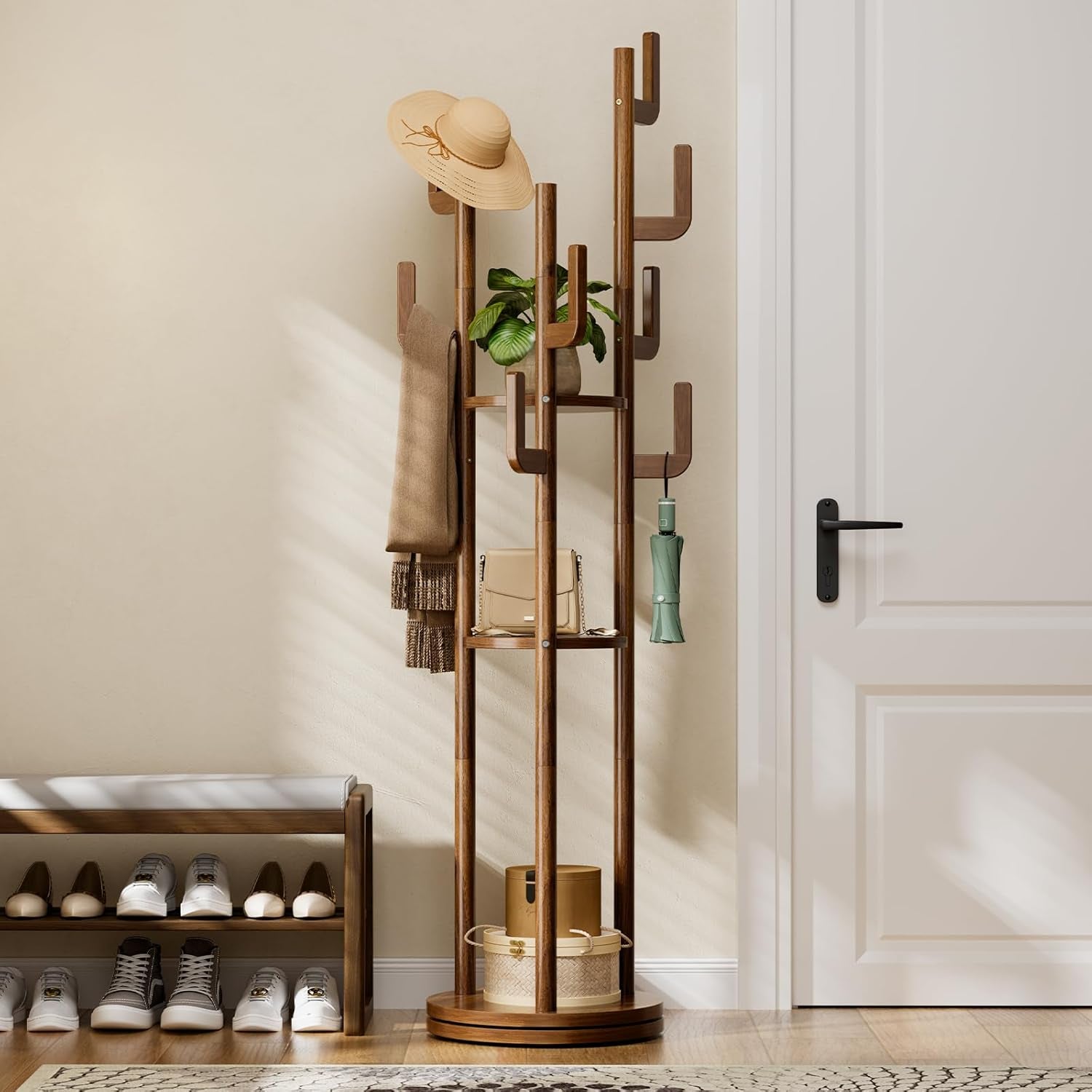 Walnut finish hall tree in an entryway with a hat, scarf and umbrella beside a shoe bench