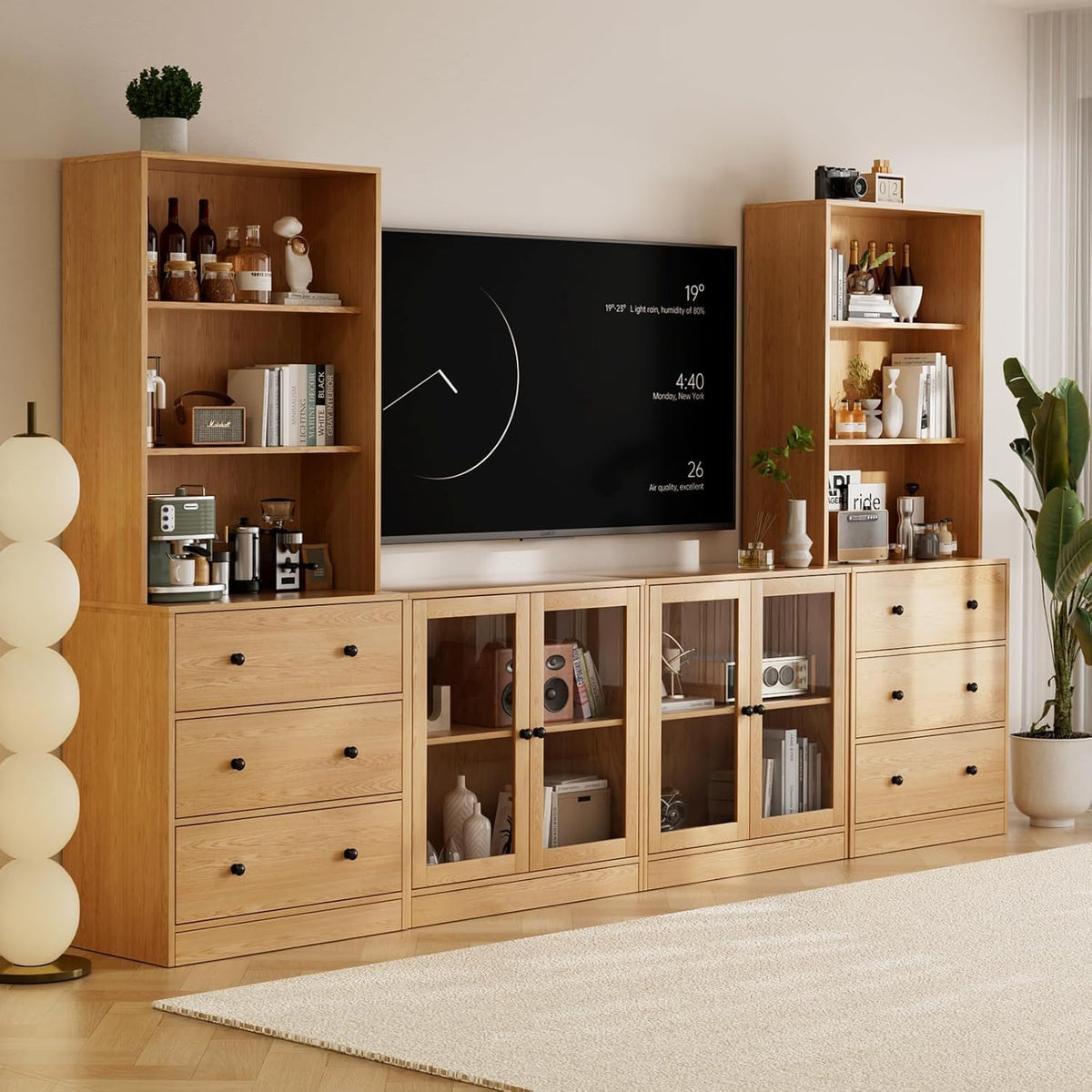 Close angled view of the natural wood cabinets showing drawers, glass-front center cabinets and shelving with decor.