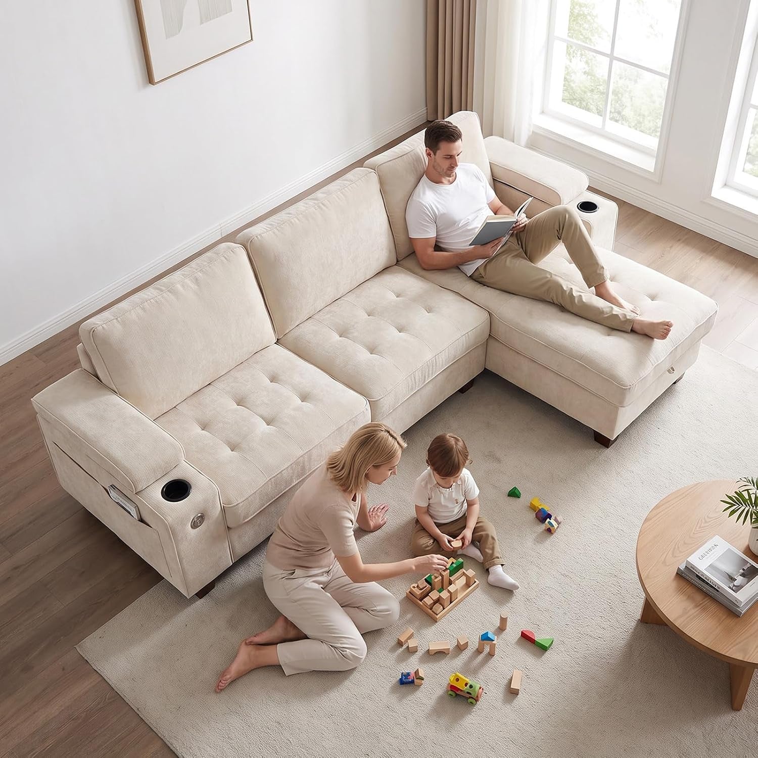 Aerial view of a beige chaise sectional with a man reclining on the chaise and a woman and child playing on the rug nearby.