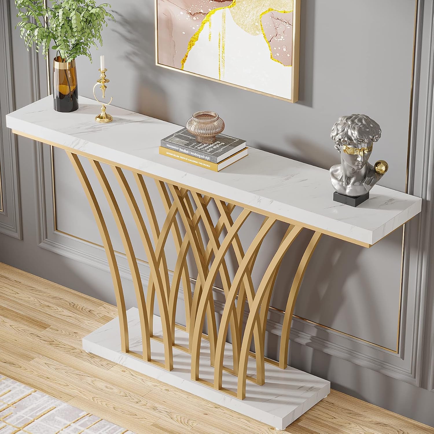 Angled close-up of console table showing the white faux marble top and gold curved metal supports over a faux marble base