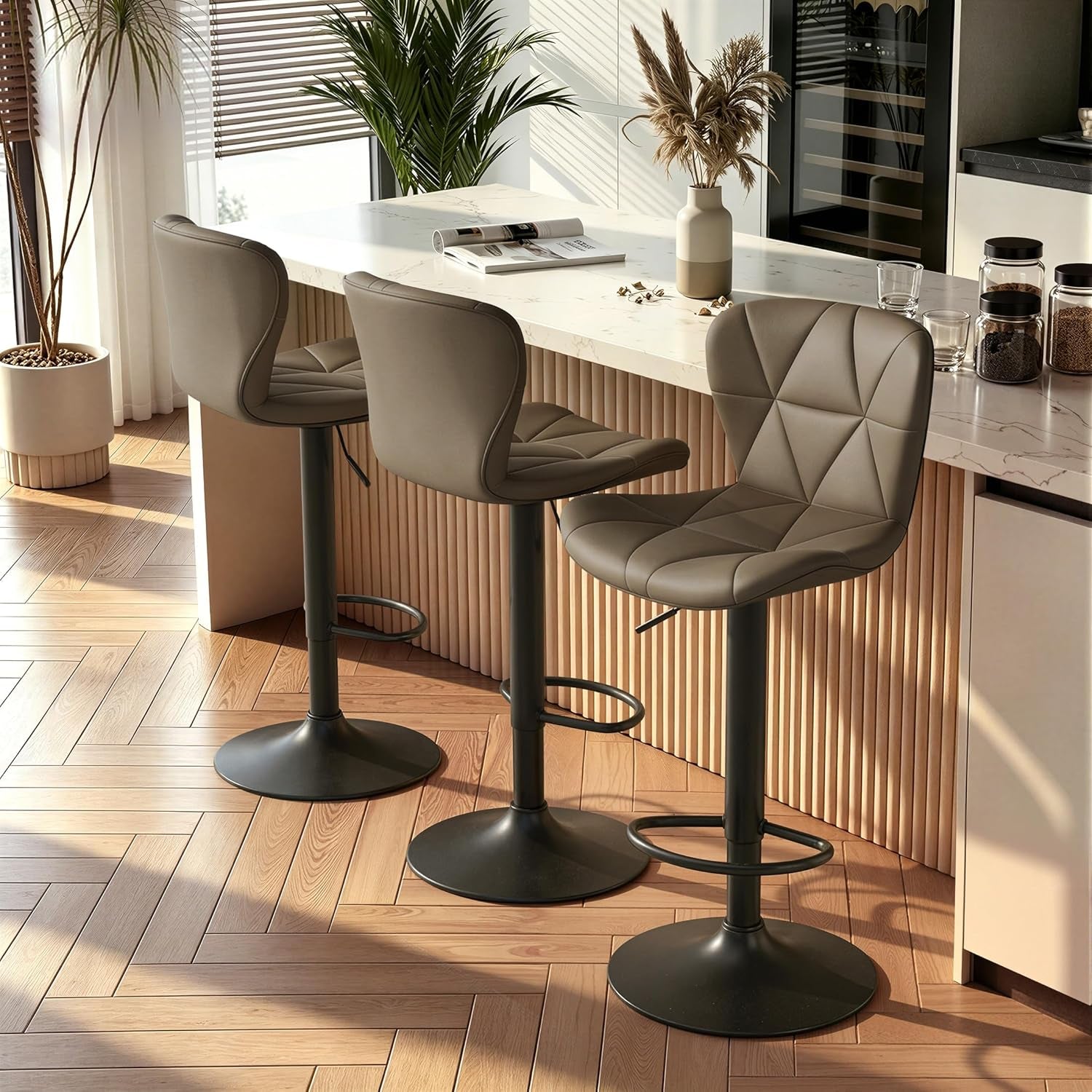 Three taupe swivel stools lined at a kitchen island, sunlight casting shadows on the floor.