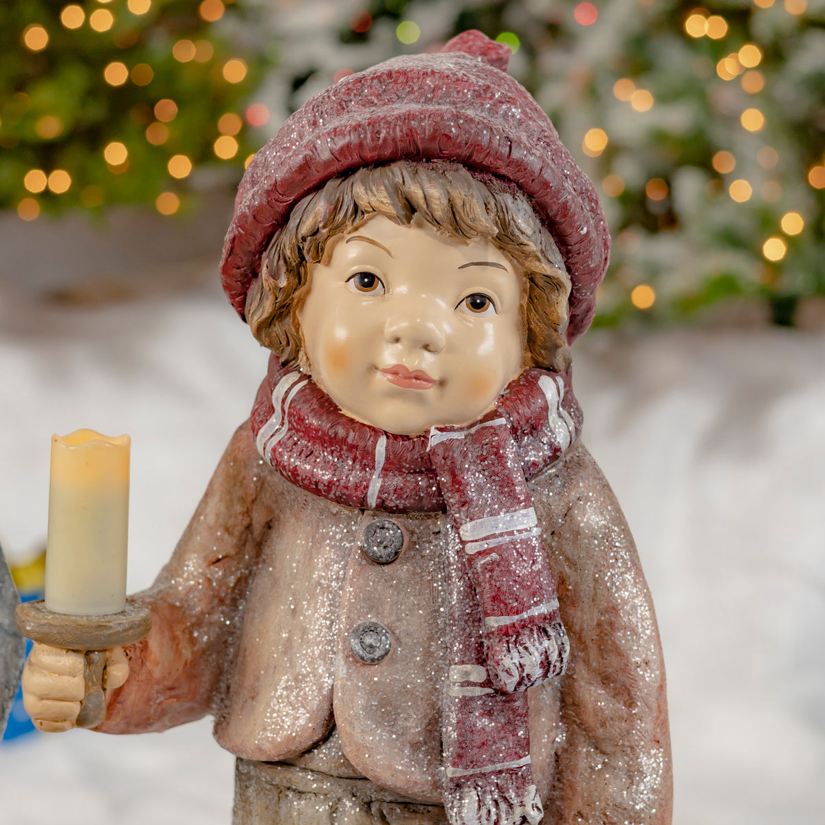 Close-up of the red-clad Christmas figure holding a candle holder