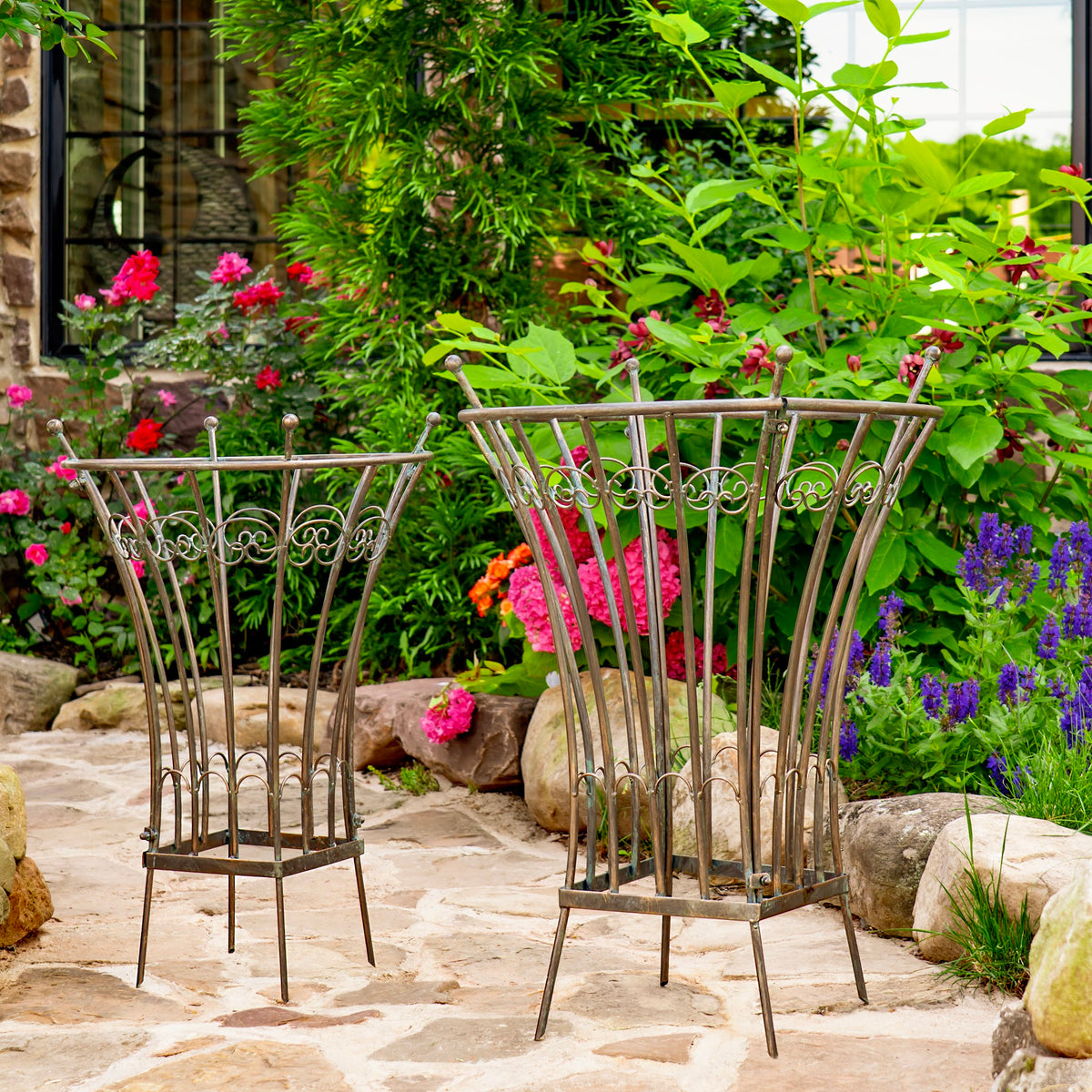 Garden stands viewed from a closer angle, showing their curved ironwork against lush greenery.