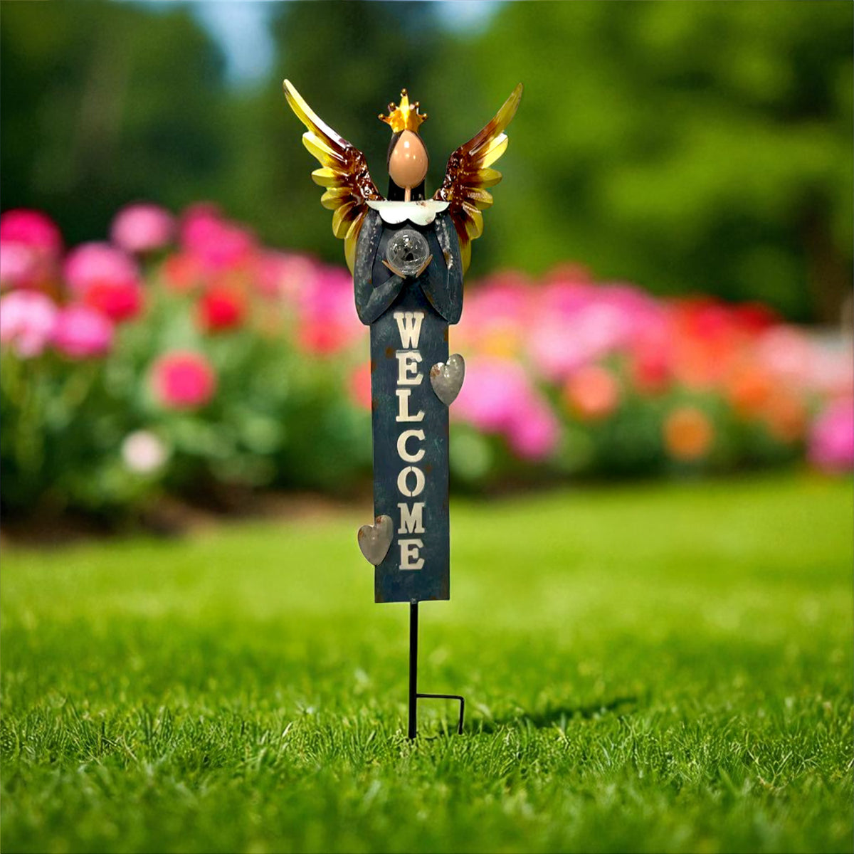 A crowned angel stake has raised metallic wings and a vertical sign with heart accents.