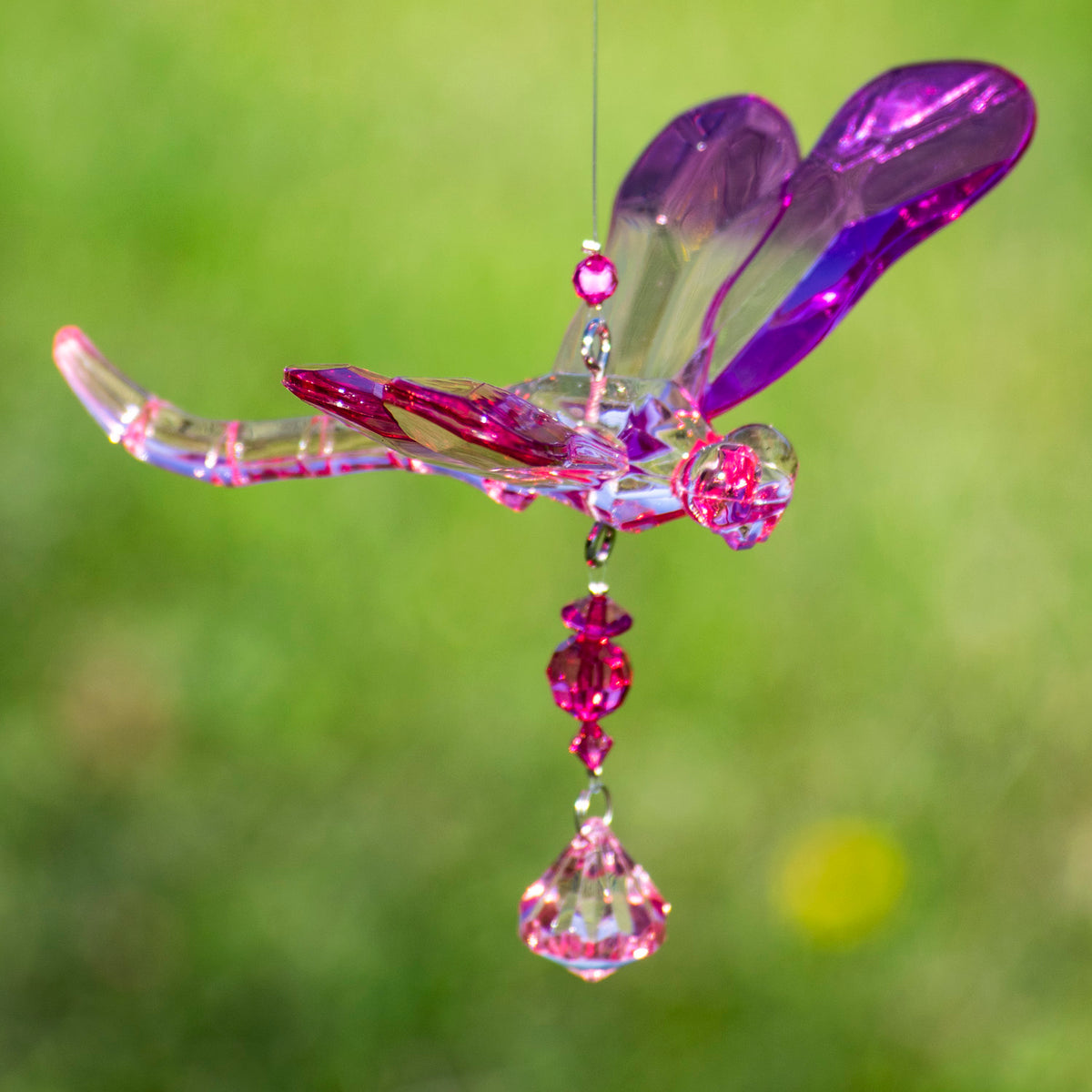 Close-up of a purple and pink dragonfly ornament with matching dangling beads.