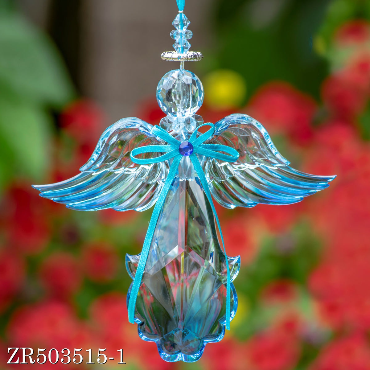 A hanging blue angel ornament shown front-on, with jeweled details, a ribbon bow, and wide wings.