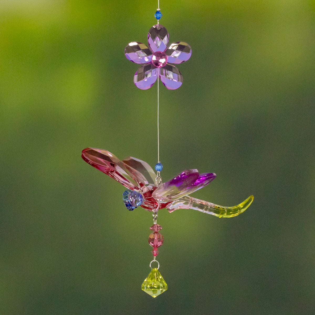 Pink and purple faceted dragonfly ornament hangs below a purple flower, finished with a lime-green drop.