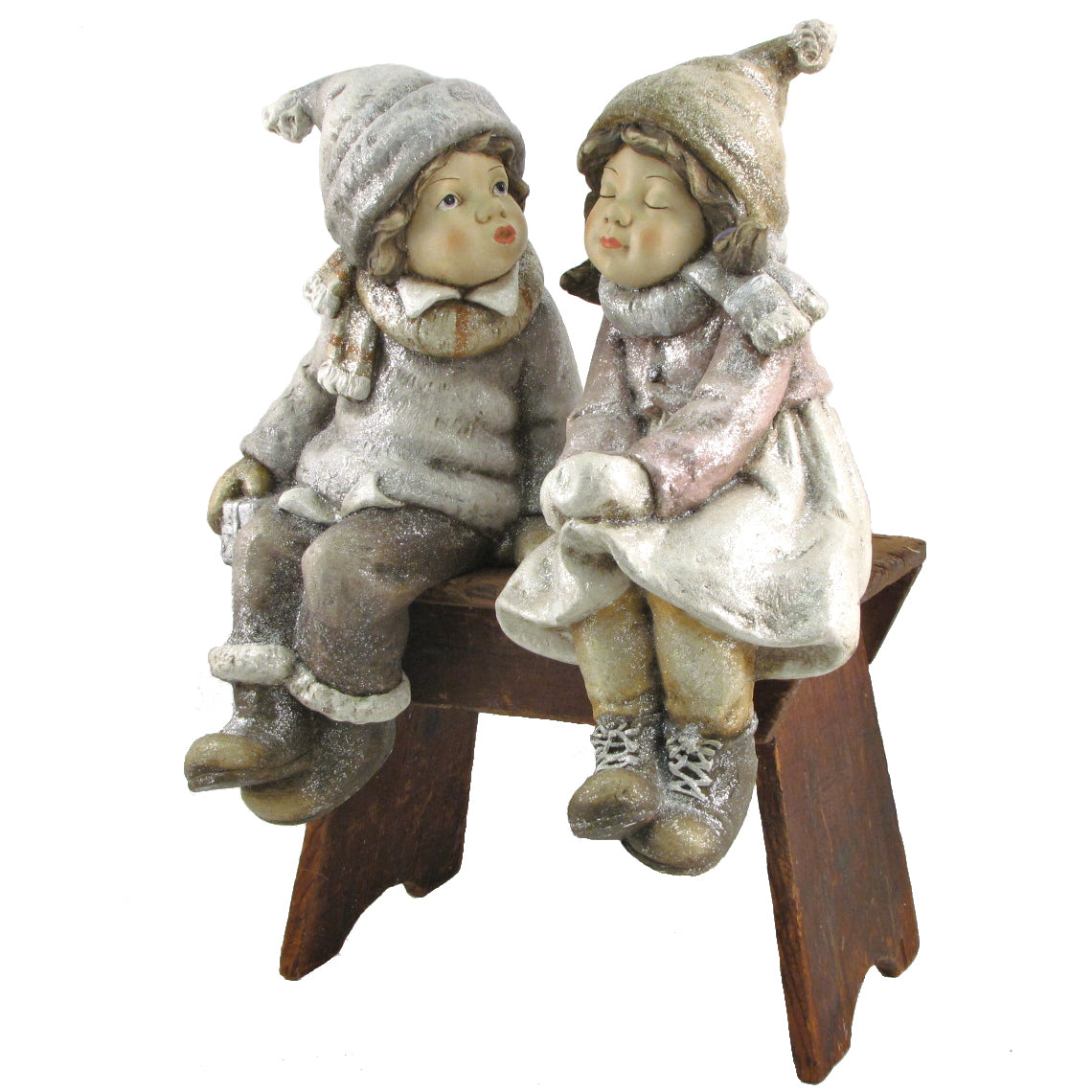 The two winter figurines sit together on a small wooden bench against a white background.