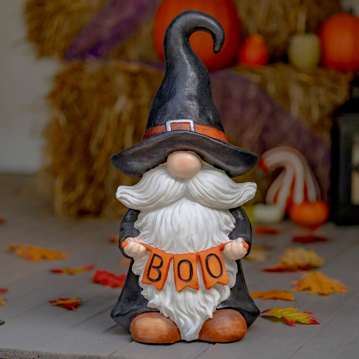 Halloween gnome witch with orange BOO sign displayed on a fall-themed tabletop