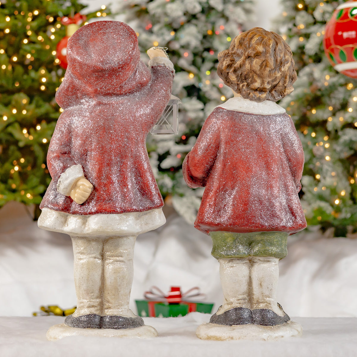 Back view of both figures, showing their red cloaks and the lantern at the side.