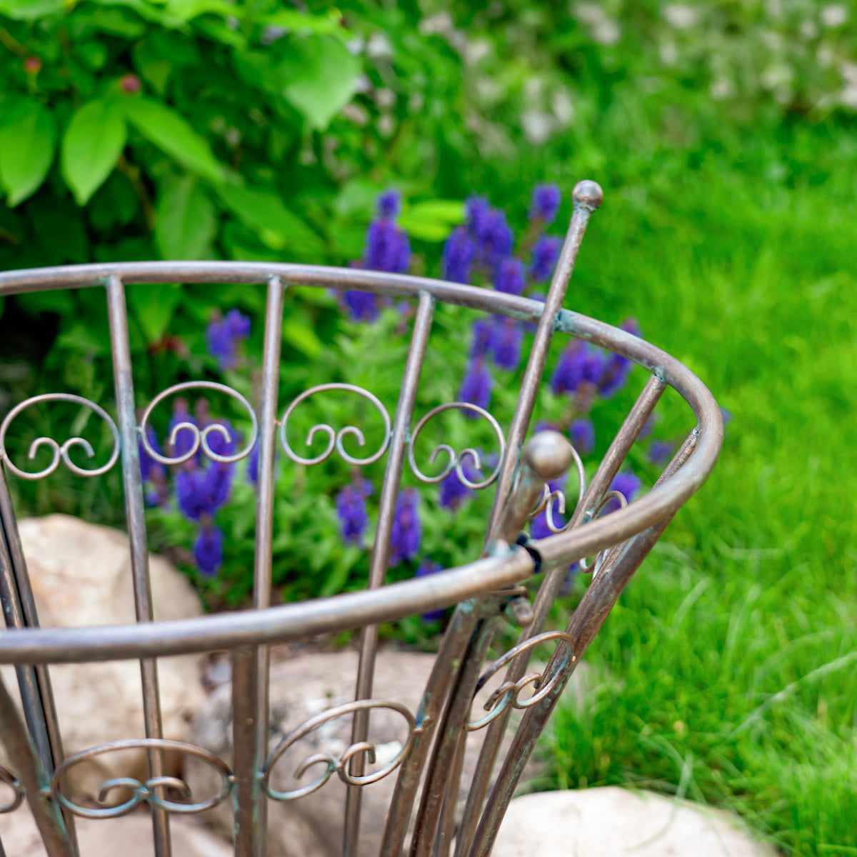 Close-up of the stand’s rounded rim, scrollwork, and capped vertical bars.