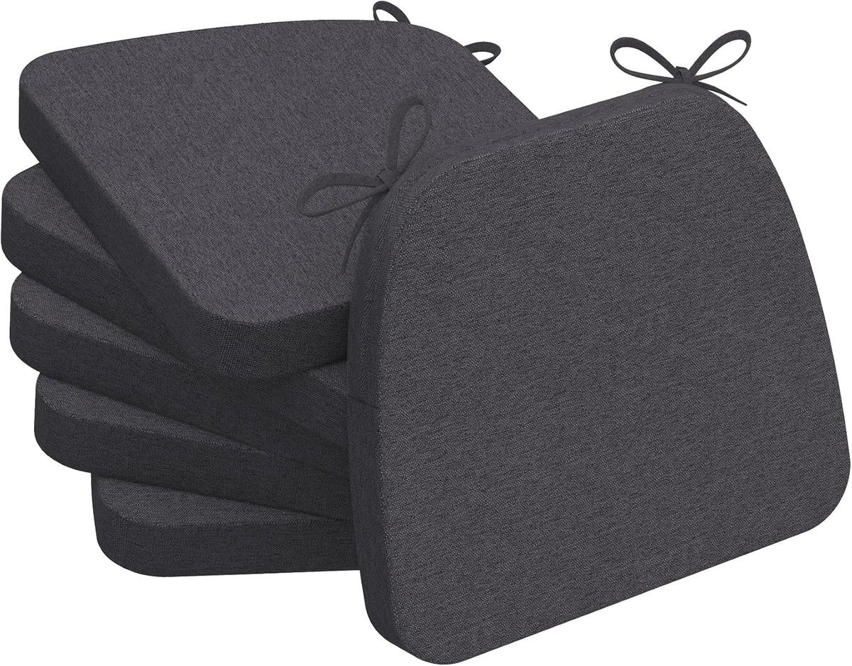 Stack of four dark charcoal gray D-shaped chair pads with visible corner tie loops