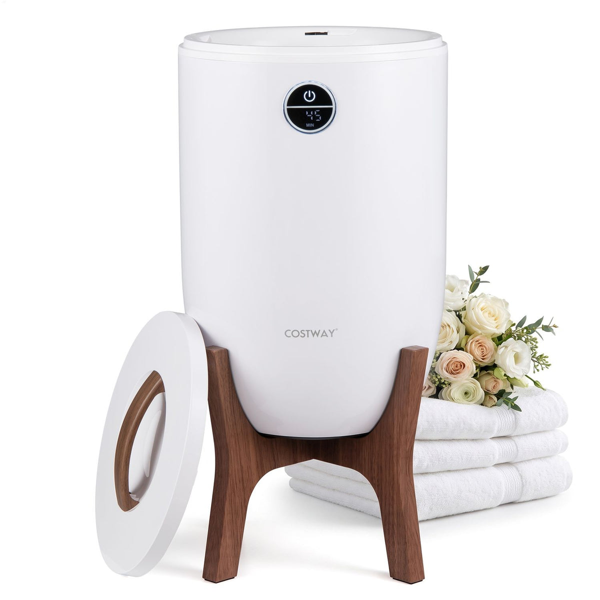 White towel warmer on a wooden stand beside its detached lid and a stack of towels.