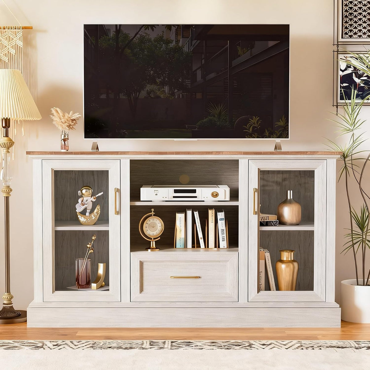 Front view of rustic white farmhouse TV stand with tempered-glass doors, central open shelves and a TV on the tabletop