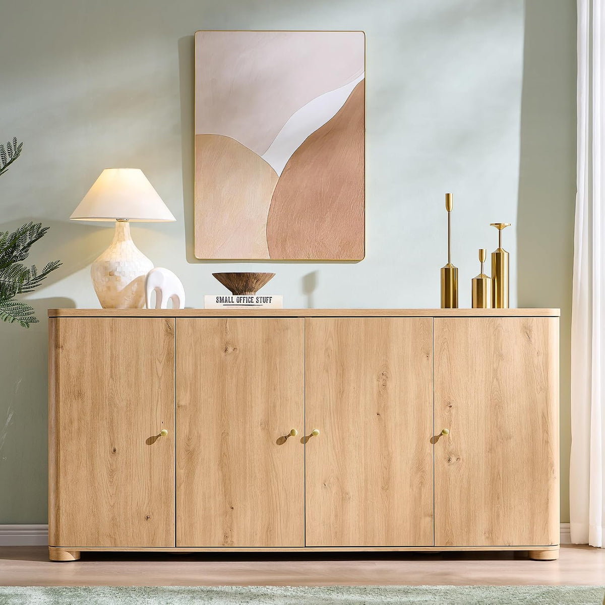 Front view of natural finish sideboard with lamp and artwork on the tabletop in a living space.