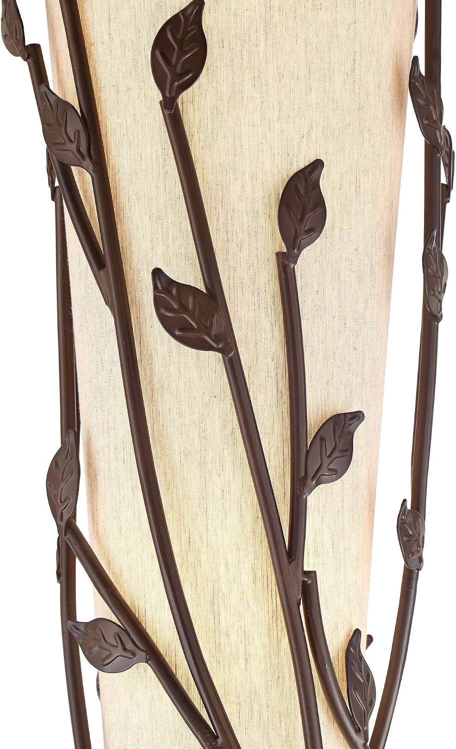 Bronze metal vine stems with sculpted leaves wrapped around a tall beige linen shade, side view