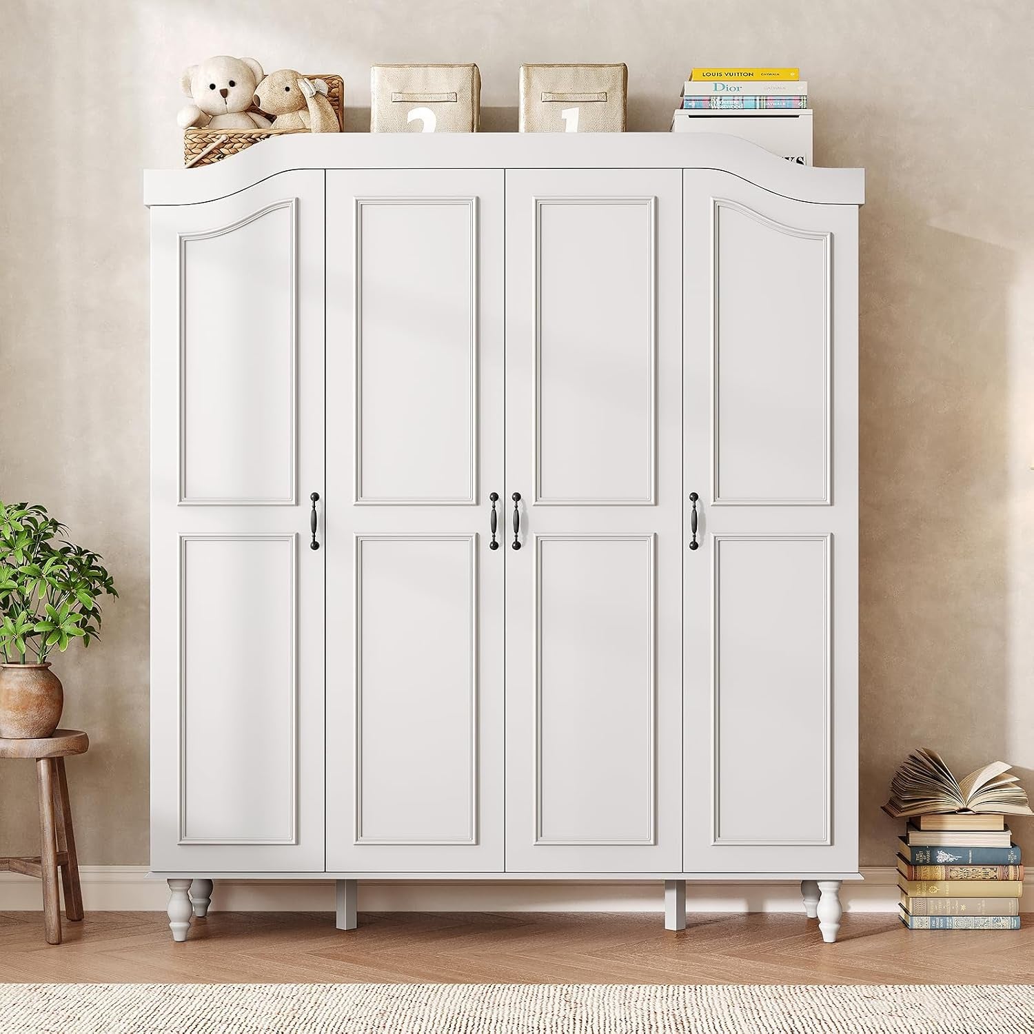Straight-on frontal view of white armoire with arched top and turned wood legs in a room