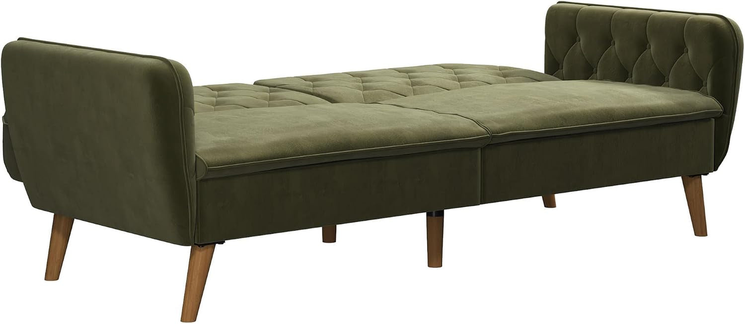Green velvet futon laid flat into a bed with tufted arms at each end