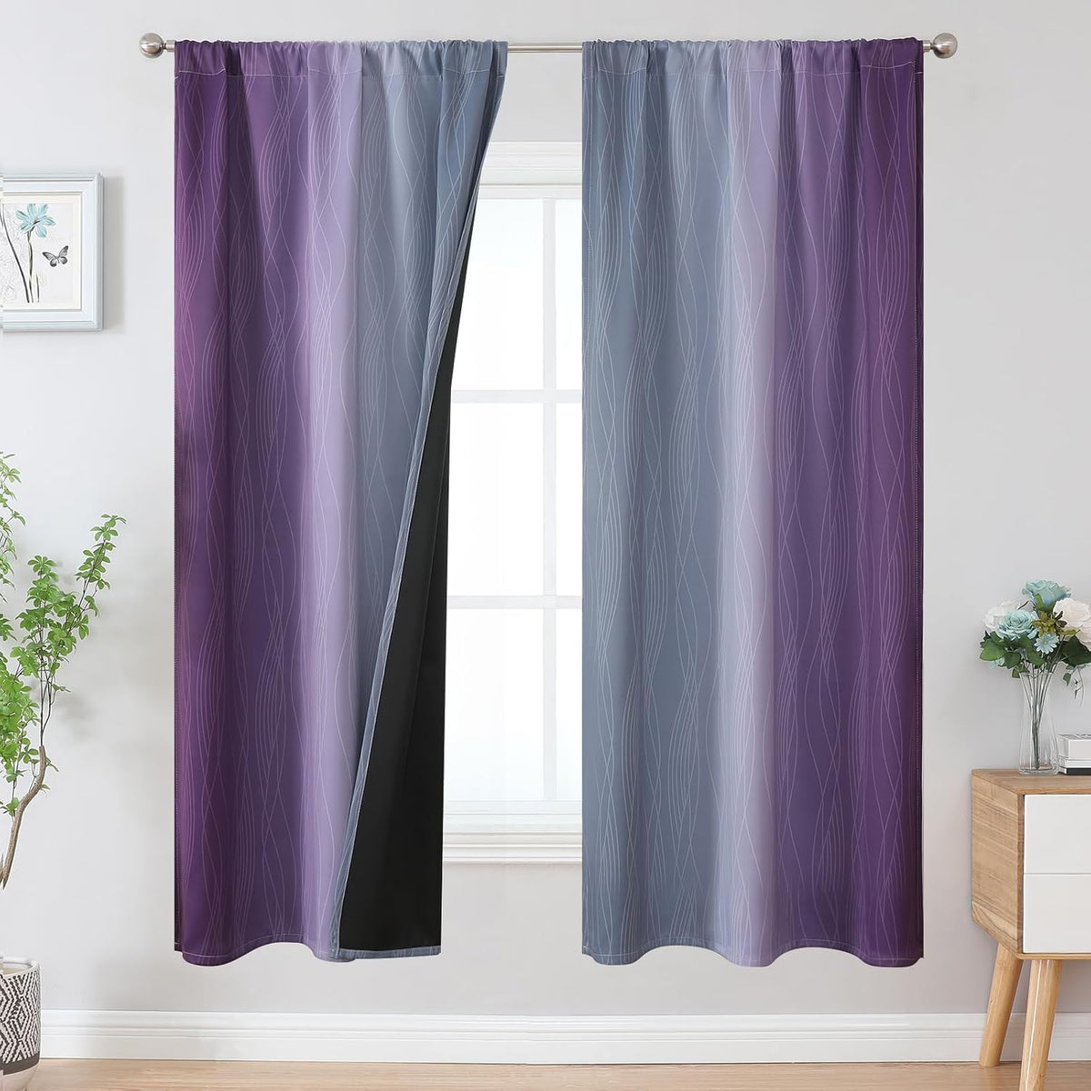 Window with two curtains in lavender to deep purple ombre, one panel pulled back showing black backing