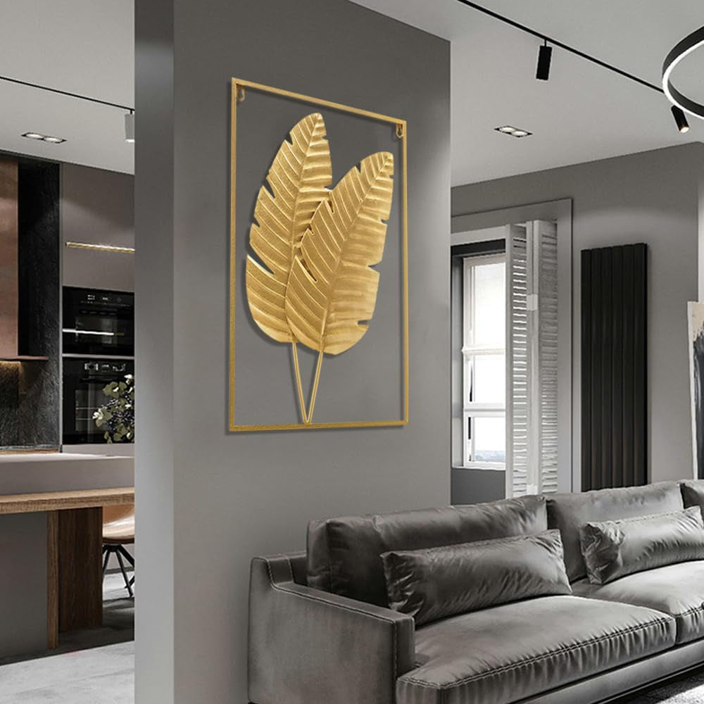 Single large gold framed metal leaf wall art mounted above a grey sofa in a modern living room