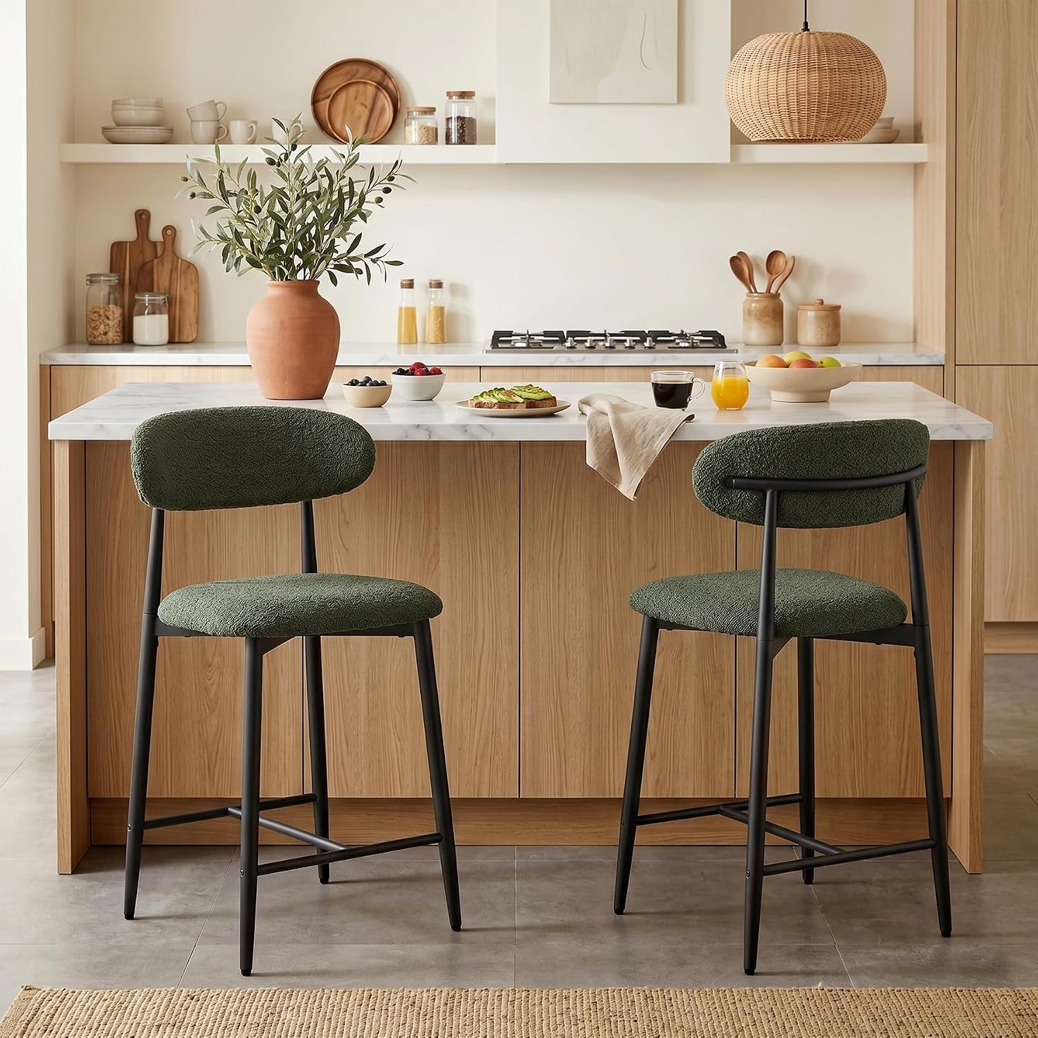 Two counter-height stools with green upholstered seats and black metal legs at a kitchen island.