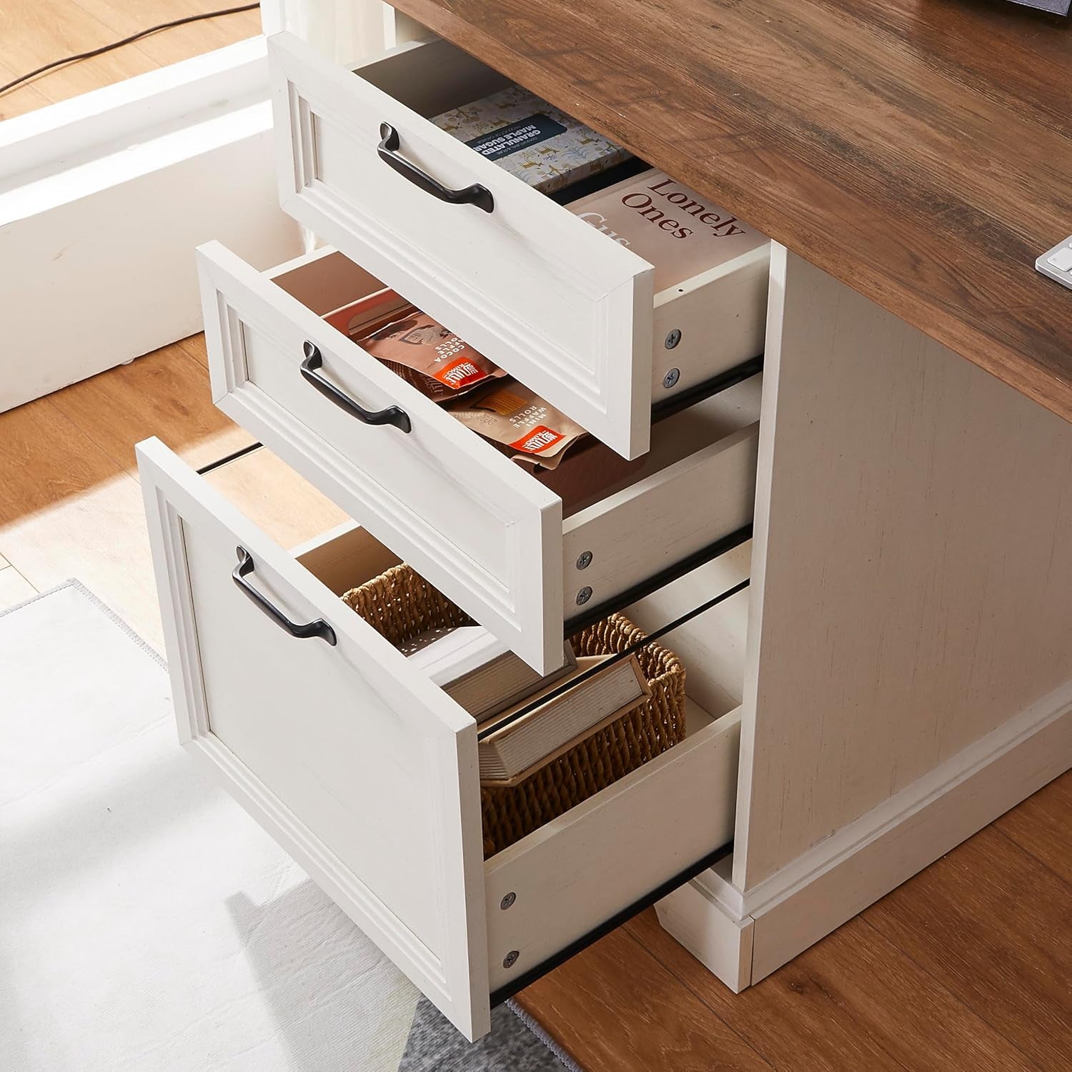 Close-up of the desk pedestal drawers open to show two smaller drawers and a larger filing drawer with metal handles