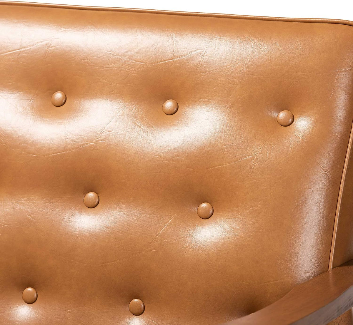 Close-up of tan button-tufted faux leather backrest showing texture and piping.