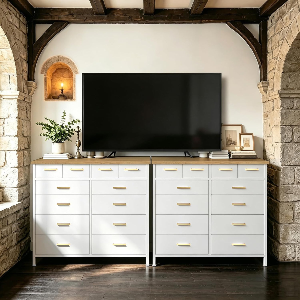 Two white tall dressers topped with a TV and decorative objects flanked by stone archways.