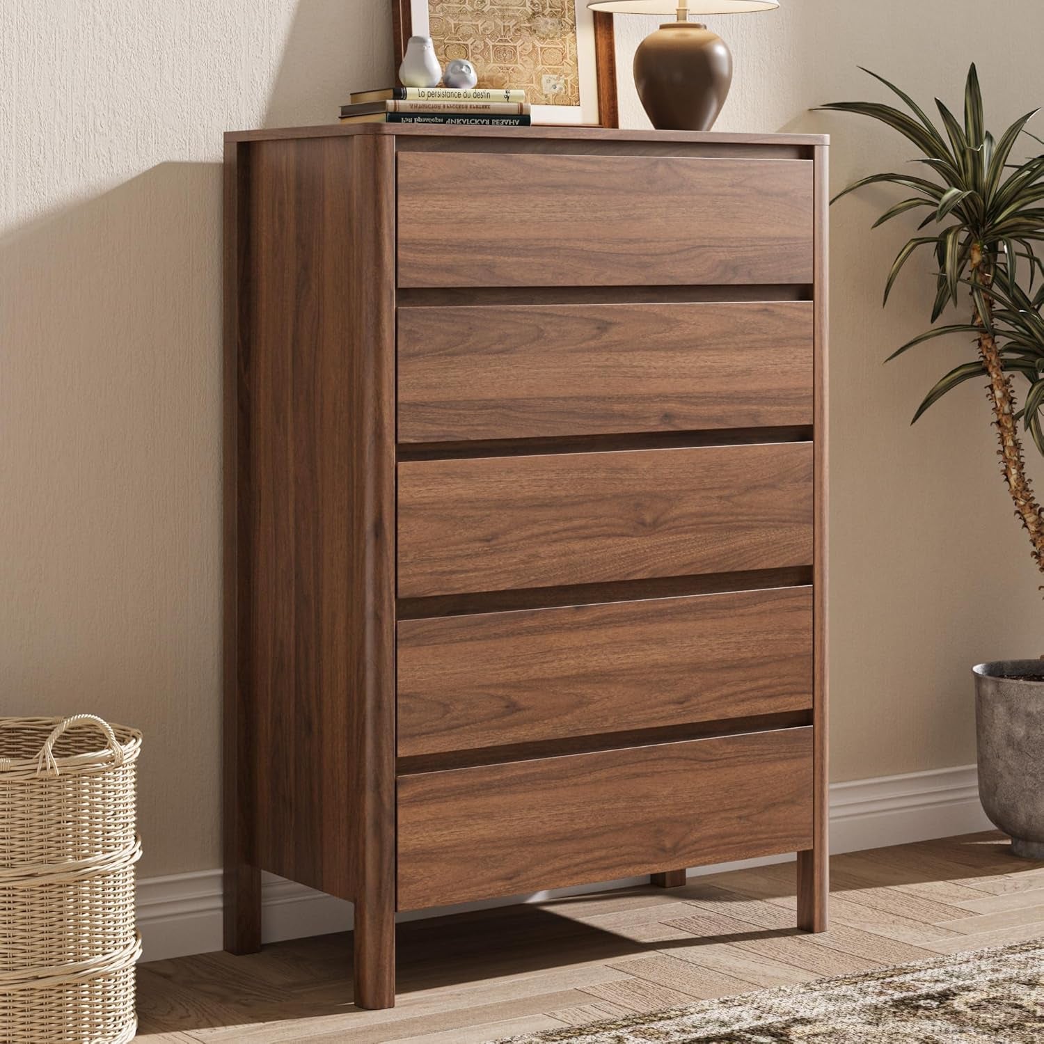 Side-angle view of a tall narrow walnut chest beside a woven basket and a potted plant on the floor.