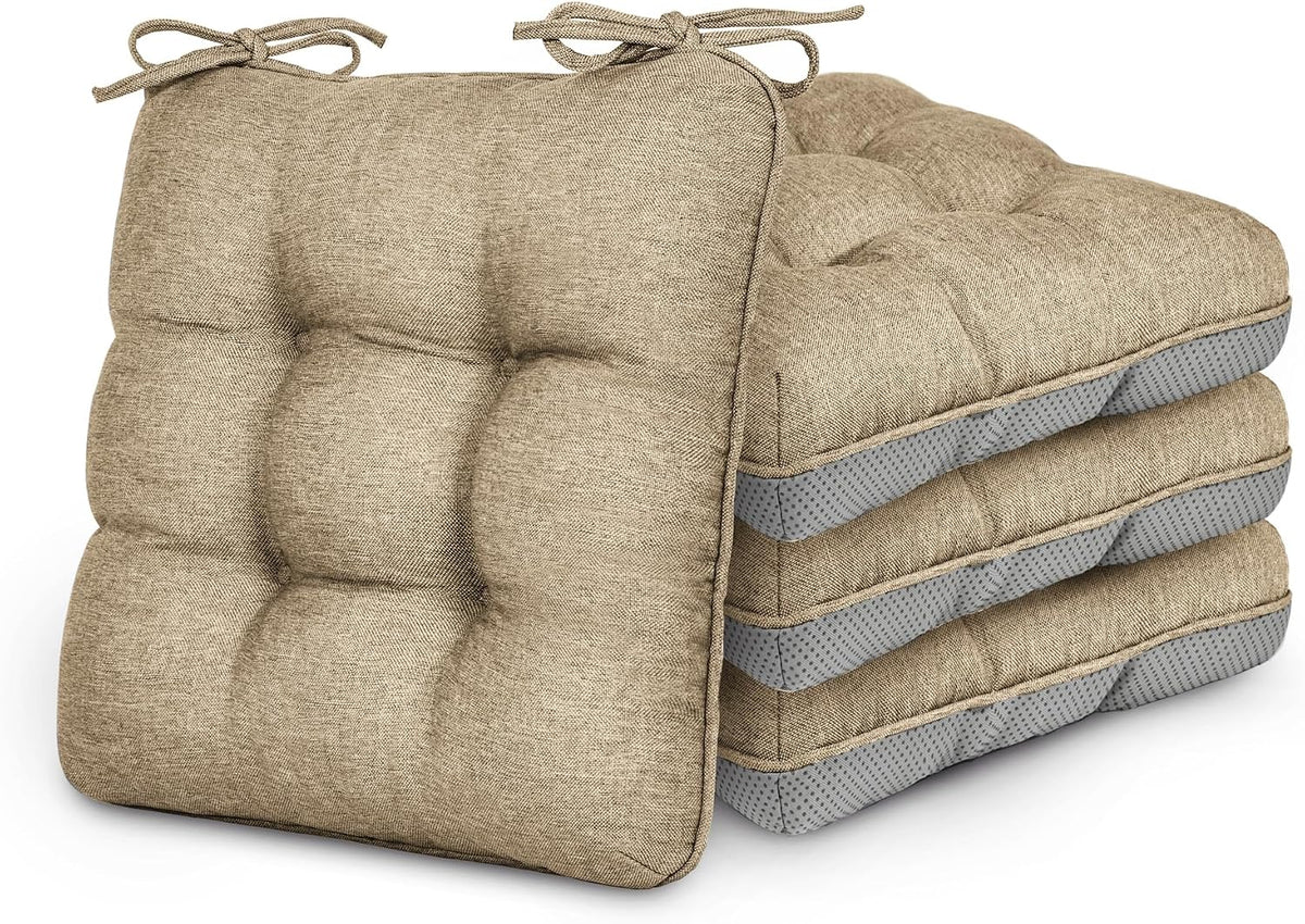Stack of four beige tufted chair cushions with tied corner straps and grey mesh undersides.