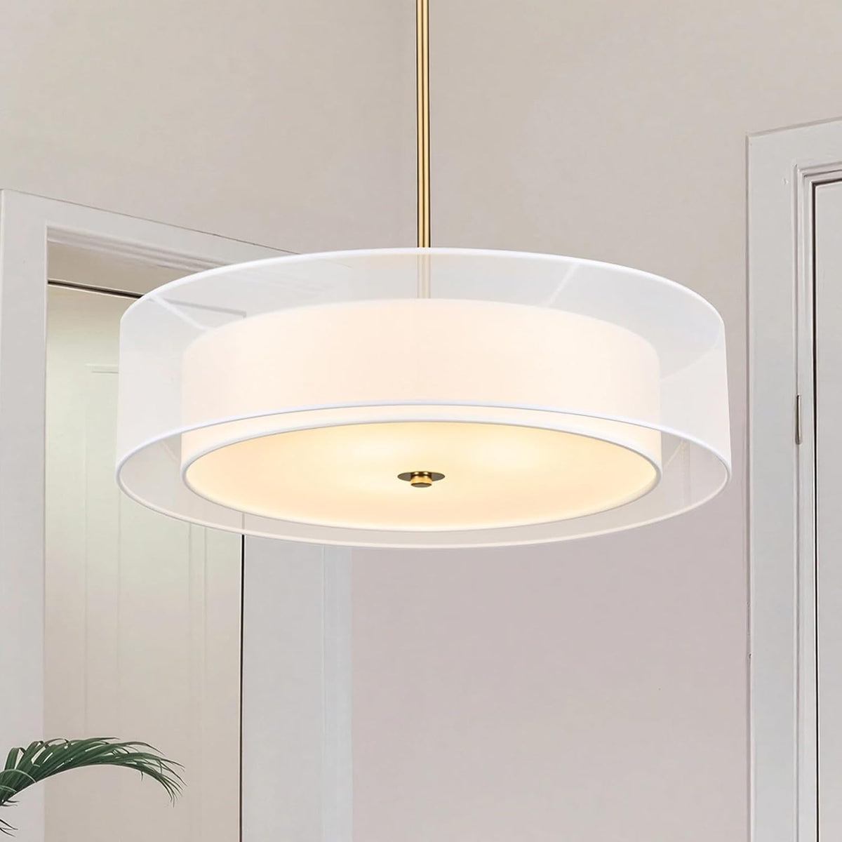 Close-up front view of a two-tier drum pendant with a white inner shade and gold suspension rod.