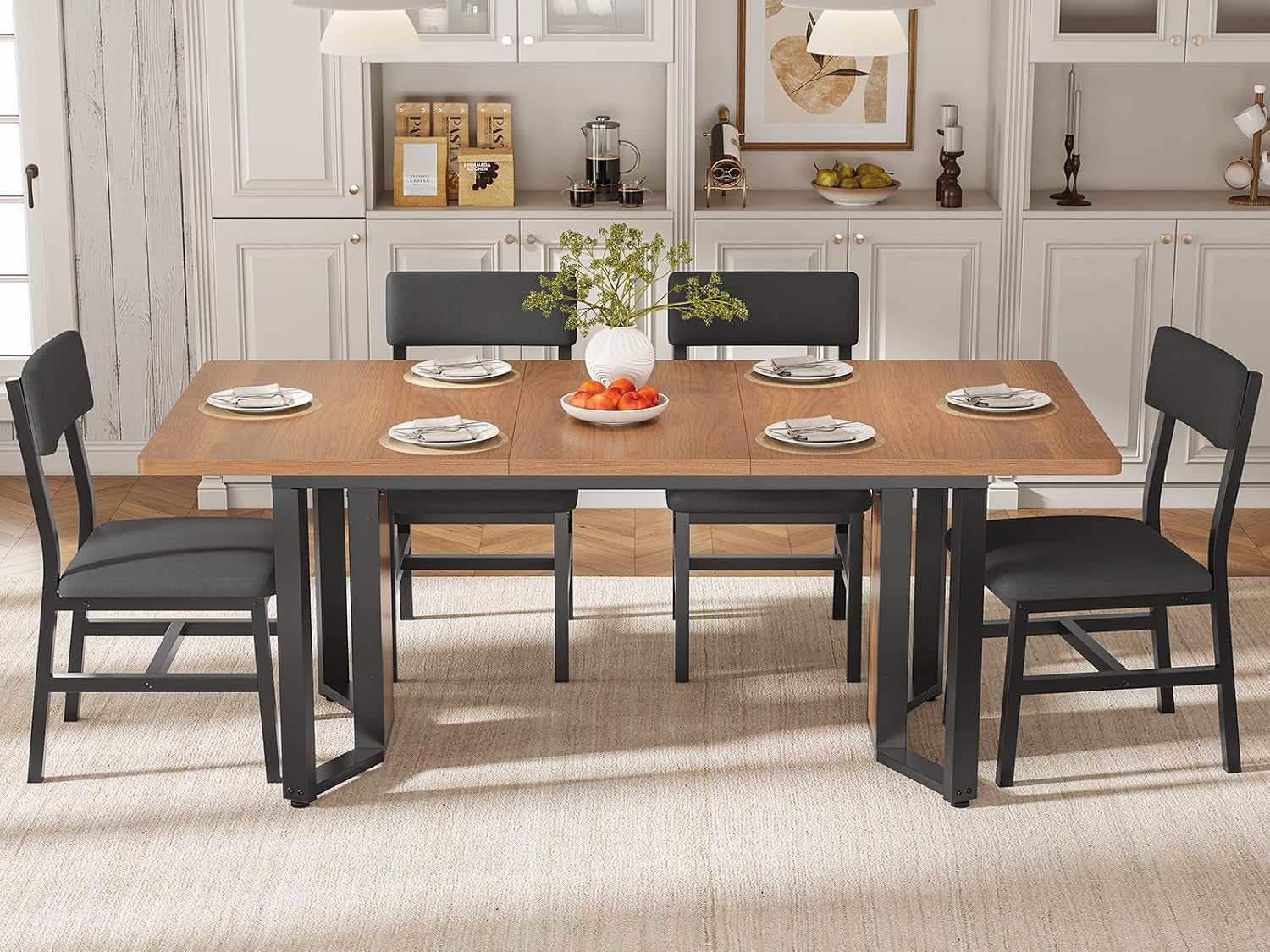 Front room view of the expanded brown dining table with four black upholstered chairs.