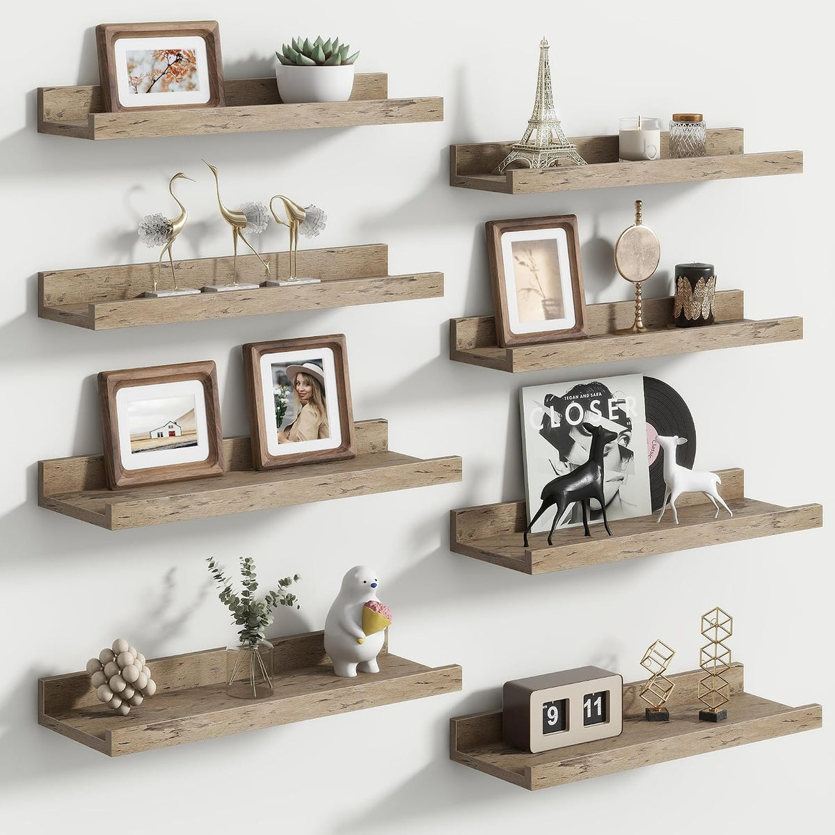 Multiple light‑wood floating ledges staggered on a wall displaying frames, small sculptures and a toy bear.