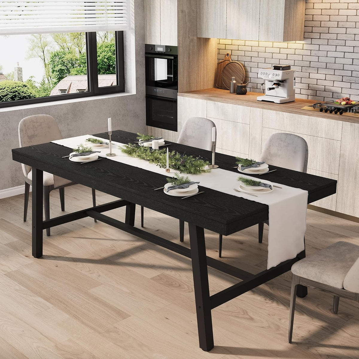 Dining table with black wood top and black metal legs set with a white runner and place settings in a kitchen.
