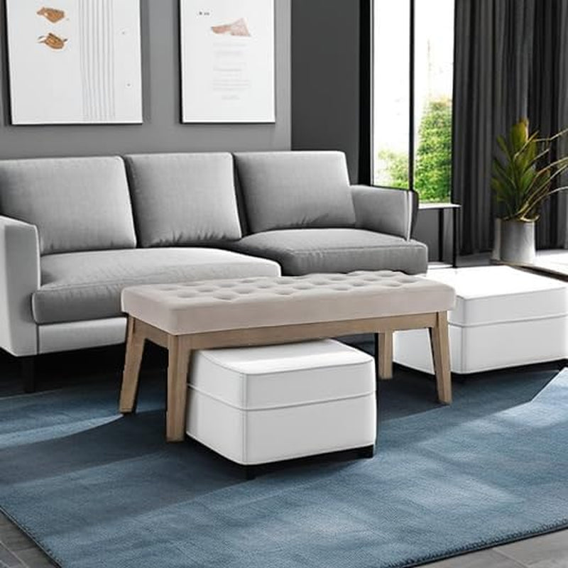 Light taupe tufted bench placed above two white ottomans in a modern living room setting