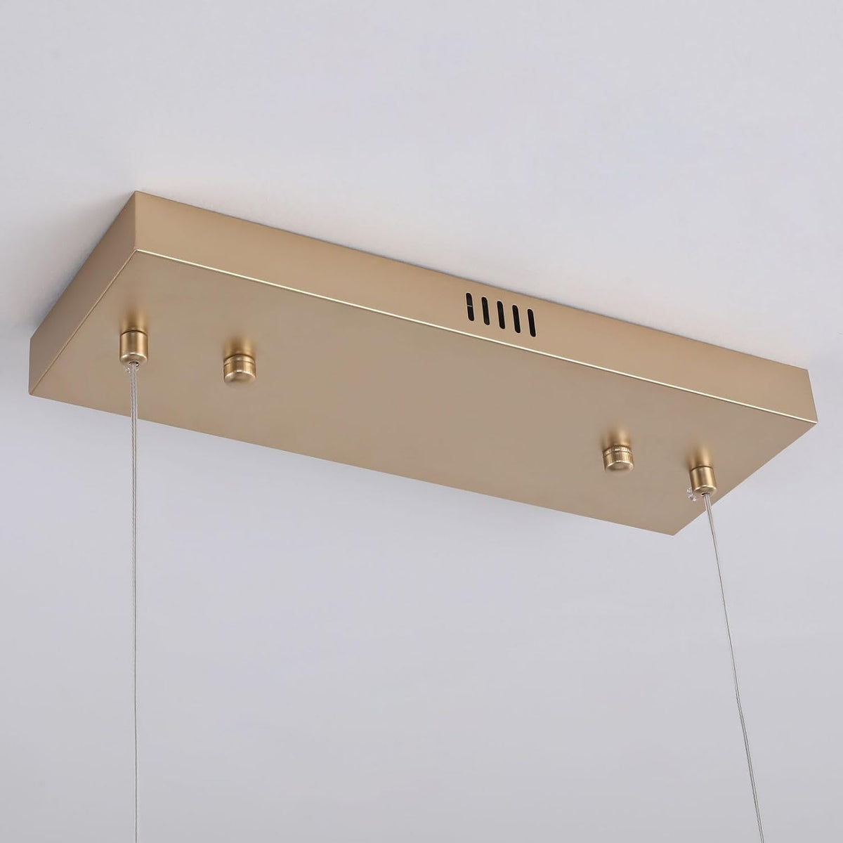 Rectangular gold ceiling canopy underside with small attachment posts and two thin suspension cables.