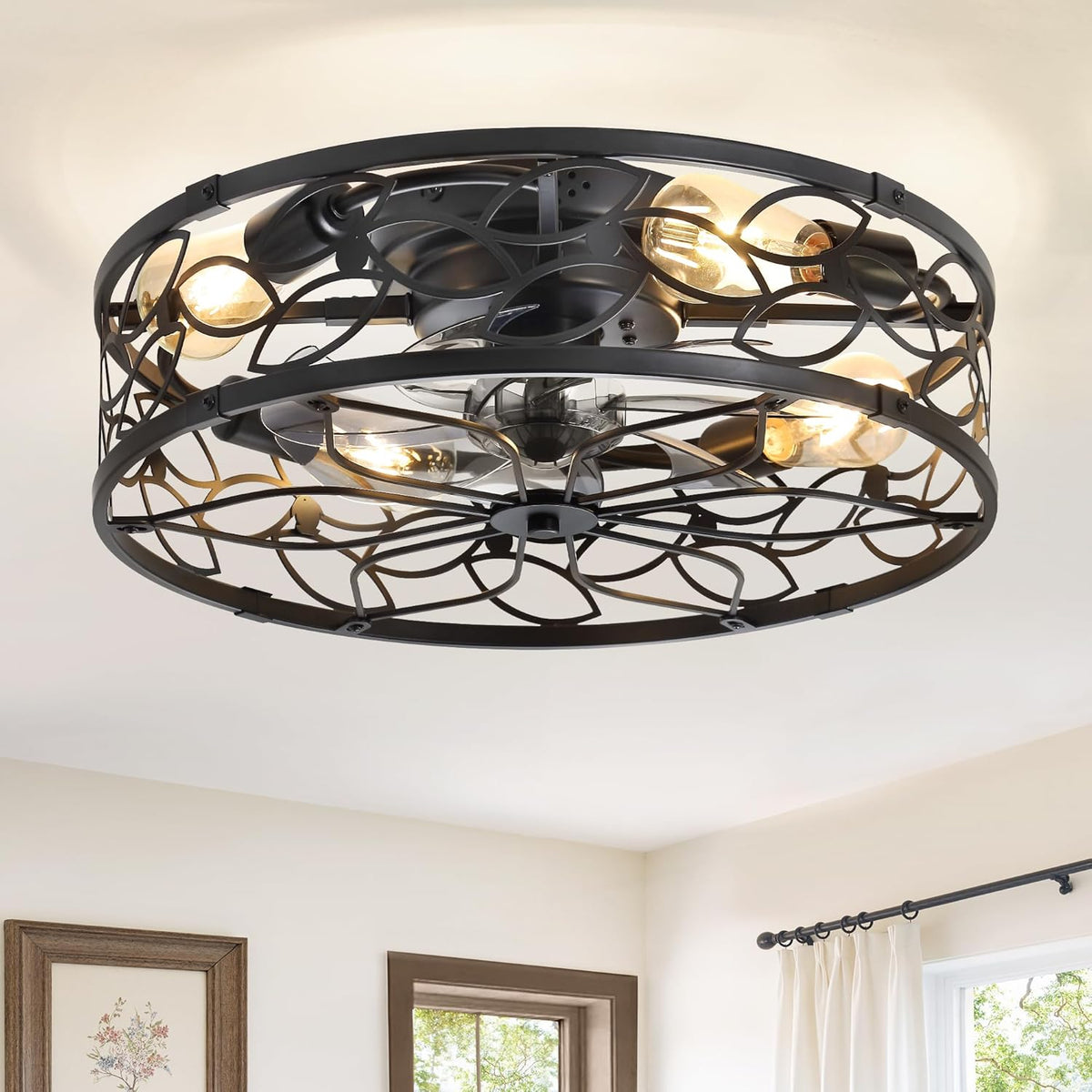 Close-up underside view of a black metal caged flush fan showing exposed bulbs and compact folding blades.