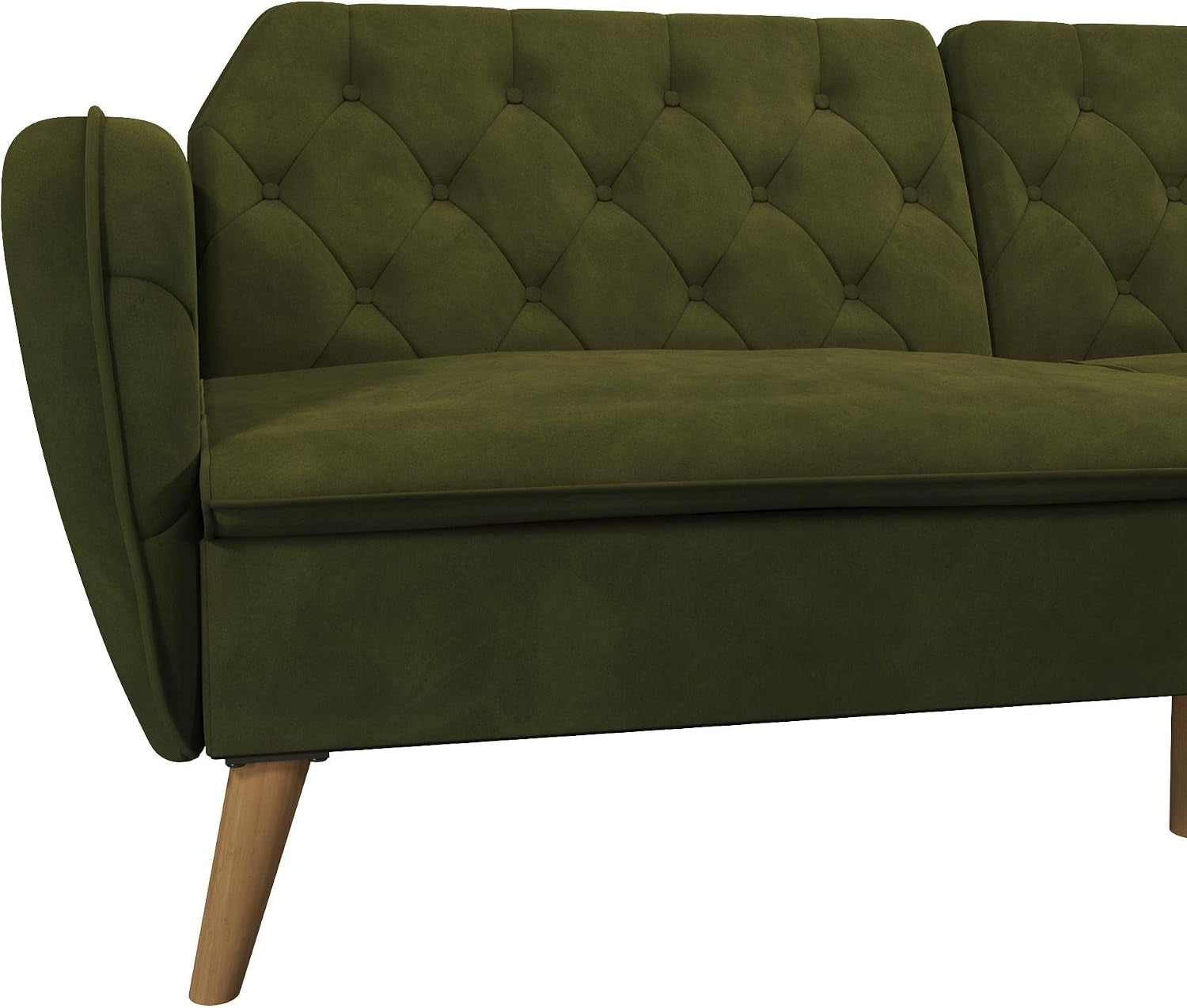 Front corner close-up of the green velvet futon showing tufted back, seat cushion, and wooden leg.