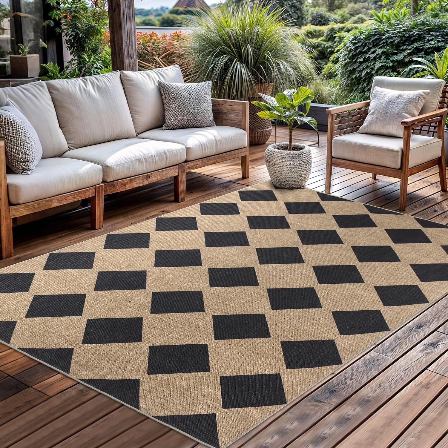 Checkerboard rug on a wooden deck beside a low white cushioned sofa and potted plants