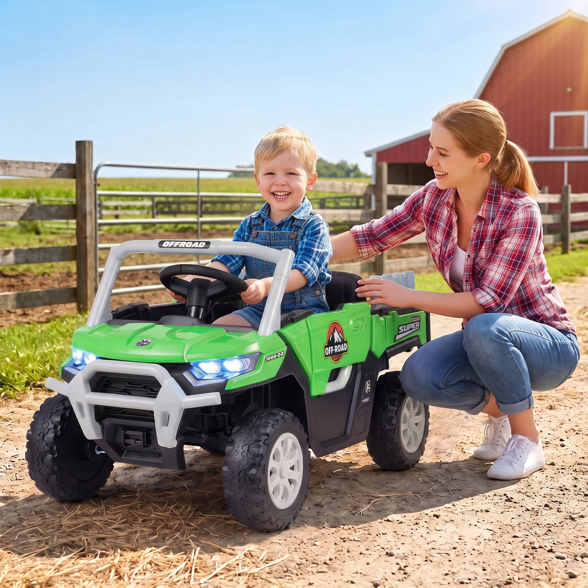 A child sits in a green ride-on truck as an adult kneels beside him.