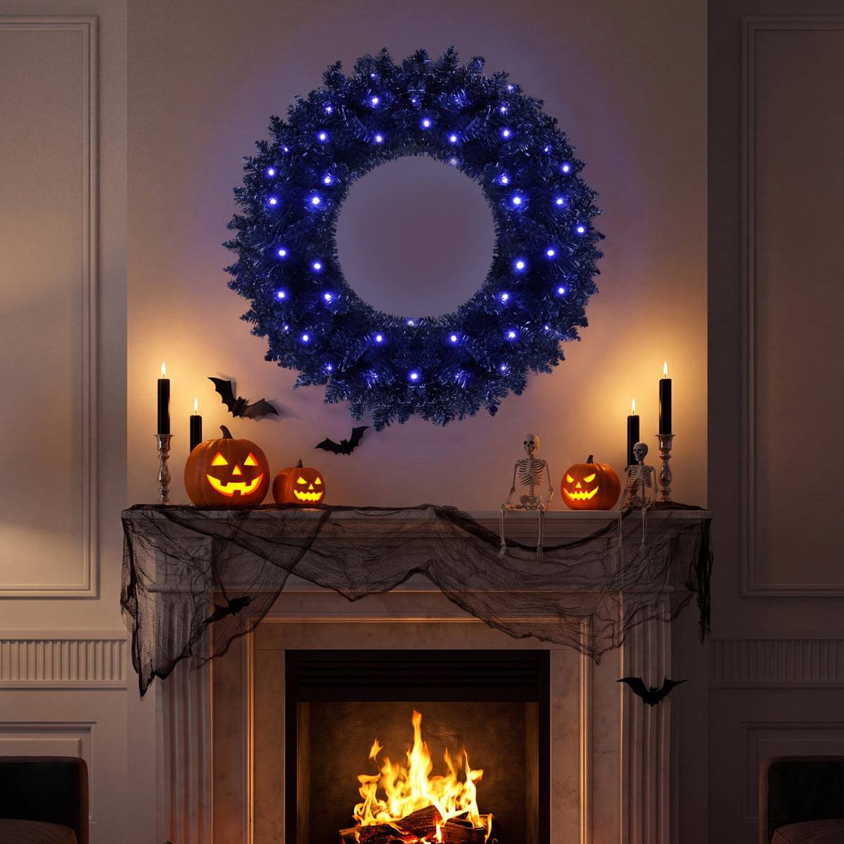 A lit wreath hangs above a fireplace decorated with pumpkins, candles, bats, and a small skeleton.