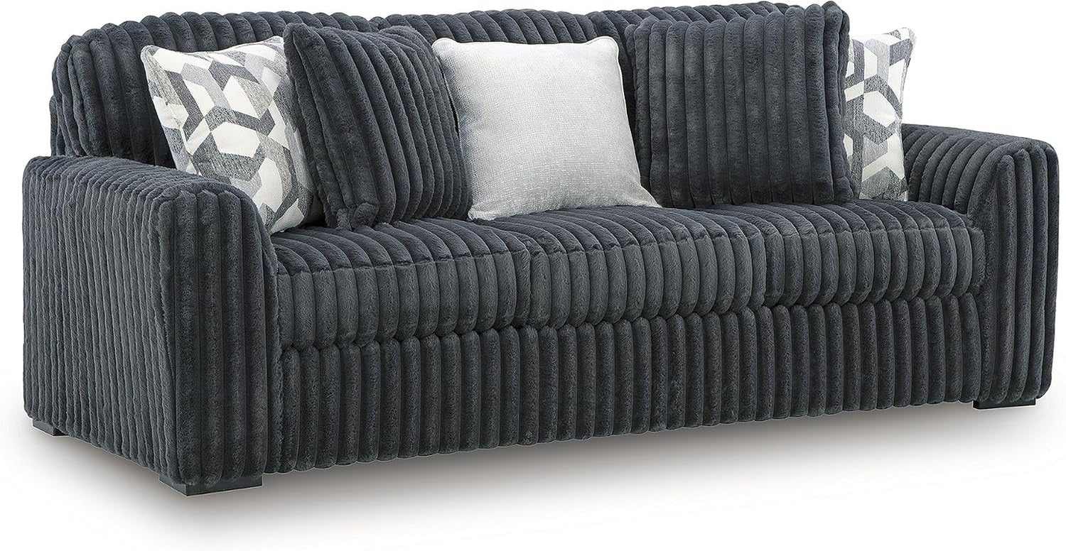 Front view of a dark charcoal corduroy sofa with three decorative pillows and channel-tufted upholstery.
