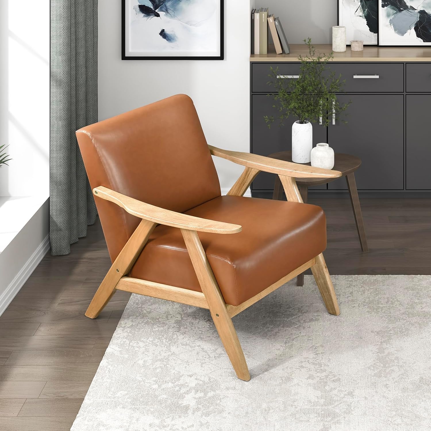 Angled view of a mid-century accent chair with light walnut frame and tan linen-look upholstery in a living room.